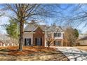 Beautiful two-story home with a brick facade, complemented by a lush, tree-filled yard at 3565 Mystic Dr, Buford, GA 30519