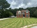 Charming two-story brick home with manicured lawn and long driveway, offering curb appeal and space at 1931 Harvest Way, Loganville, GA 30052