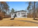 Elegant white home with a grand entrance, multiple balconies, and mature trees on a well-manicured lawn at 3670 River Mansion Dr, Peachtree Corners, GA 30096