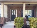 Inviting front porch with brick accents, decorative wreath on the front door, and space for seating at 3429 Lake End Dr, Loganville, GA 30052