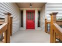 Inviting front porch with a vibrant red door and decorative sidelights, framed by wooden railings at 2667 Stonebrook Ne Ct, Roswell, GA 30075