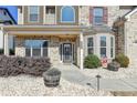 Inviting front porch with brick accents, decorative planters, and a charming entrance at 3488 In Bloom Way, Auburn, GA 30011