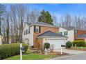 Two-story home with brick and siding exterior, an attached garage, and a manicured front lawn with mature landscaping at 3815 Glen Laurel Ct, Cumming, GA 30040