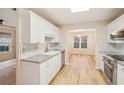 Bright kitchen featuring white cabinets, stainless steel appliances, and hardwood floors at 3815 Glen Laurel Ct, Cumming, GA 30040