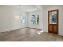 Sunlit living room showcasing hardwood floors, transom window and elegant chandelier at 114 Terrace Ne Dr, Atlanta, GA 30305