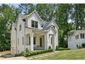 Beautiful two-story white brick home with a covered porch and lush green lawn at 116 Terrace Dr, Atlanta, GA 30305