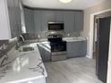 Modern kitchen featuring stainless steel appliances, ample counter space, and gray cabinets at 25 Oak Crest Ct, Covington, GA 30016