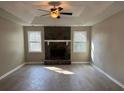 Spacious living room features a stone fireplace, tray ceilings, and dual windows that provide natural light at 25 Oak Crest Ct, Covington, GA 30016