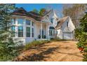 Detailed view of white brick home featuring a turret and attached garage at 1516 Ashford Club Ne Ct, Brookhaven, GA 30319