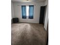 Neutral bedroom with a black dresser, blue curtains, plush carpeting and ample natural light at 135 Windy Hill Rd, Fayetteville, GA 30214
