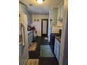 A galley kitchen features vintage light blue cabinets and modern black appliances at 135 Windy Hill Rd, Fayetteville, GA 30214