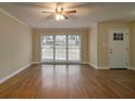 Bright living room with hardwood floors, a large window with blinds and a white door at 2917 Toney Dr, Decatur, GA 30032