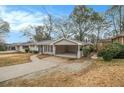 Ranch home with covered carport and sidewalk leading to the front, set against a backdrop of mature trees at 2917 Toney Dr, Decatur, GA 30032