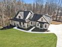 Aerial view of a stylish farmhouse featuring a covered porch, black framed windows and pristine landscaping at 7760 E Cherokee Dr, Canton, GA 30115