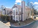 View of the side and rear of a gray townhouse, highlighting its architectural details and surrounding landscaping at 102 Johnson Ct, Decatur, GA 30030