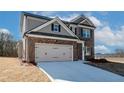 Two-story brick home featuring a two-car garage and long drive with new concrete at 4433 Eastbrook Pl, Snellville, GA 30039
