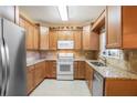 Well-lit kitchen with wooden cabinetry, tile backsplash, granite counters, and stainless steel refrigerator at 2160 Berryhill Se Cir, Smyrna, GA 30082
