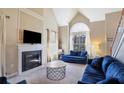 Cozy living room features a fireplace, plush blue seating, and abundant natural light from a large arched window at 2160 Berryhill Se Cir, Smyrna, GA 30082