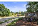 Stone community sign with manicured landscaping and a view of the surrounding greenery at 866 Lakemont Dr, Canton, GA 30114