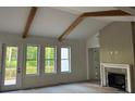 Bright living room featuring vaulted ceilings, exposed wood beams, a fireplace and many windows at 866 Lakemont Dr, Canton, GA 30114