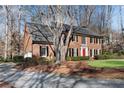 Inviting brick home with a well-maintained lawn, black shutters and a long driveway at 2170 Azalea Dr, Roswell, GA 30075