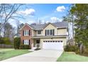 Inviting two-story home boasting a brick facade, complementary siding, a spacious driveway, and a neatly maintained lawn at 3997 Riversong Ct, Suwanee, GA 30024