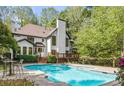 Relaxing backyard oasis with a sparkling pool, spa, patio, and lush greenery for ultimate outdoor enjoyment at 880 Cold Harbor Dr, Roswell, GA 30075