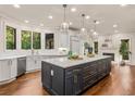 Open-concept kitchen with an oversized island, white quartz countertops, stainless steel appliances, and hardwood floors at 880 Cold Harbor Dr, Roswell, GA 30075