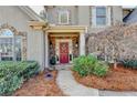 Inviting front entrance with stone accents and a red door framed by lush greenery at 525 Tilbury Dr, Suwanee, GA 30024