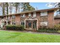 Attractive brick townhouse featuring stone accents, a covered porch, and a well-kept lawn at 2412 Peachwood Circle Northeast Ne Cir # 3, Atlanta, GA 30345