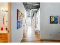 Bright hallway with modern art, wood floors, and exposed ductwork on the ceiling at 3235 Roswell Ne Rd # 919, Atlanta, GA 30305