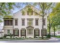 An elegant, white home with symmetrical windows, dark shutters, and mature trees at 301 Abercorn Sq, Peachtree City, GA 30269