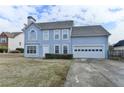 Two-story home with a blue facade, attached two-car garage and manicured front yard at 312 Jodeco Station E Cir, Stockbridge, GA 30281