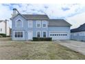 Two-story home with a blue facade, attached two-car garage and manicured front yard at 312 Jodeco Station E Cir, Stockbridge, GA 30281