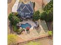 An aerial view of the property, showcasing the pool, patio area, large lawn, and surrounding greenery at 410 Hickory Fairway Ct, Woodstock, GA 30188