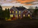 Beautiful brick home at dusk with illuminated windows and a serene setting at 410 Hickory Fairway Ct, Woodstock, GA 30188
