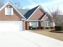 Attractive brick home with a two-car garage and a well-kept front lawn at 735 Sunset Ridge Ln, Lawrenceville, GA 30045