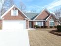 Well-maintained brick home with a two-car garage and landscaped front yard at 735 Sunset Ridge Ln, Lawrenceville, GA 30045