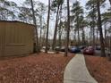 Parking area behind condo units among tall trees at 5820 Par Four Ct, Lithonia, GA 30038