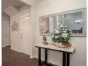 Entryway featuring a decorative table with flowers, mirror, and dark hardwood floors at 2101 Slick Stone Dr, Snellville, GA 30078