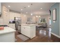 Open-concept living space with a kitchen island, modern furnishings, and hardwood floors at 2101 Slick Stone Dr, Snellville, GA 30078