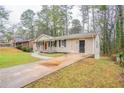 Side view showcasing the home's brick exterior, a driveway leading to the side door, and a well-kept front yard at 3527 Glenview Sw Cir, Atlanta, GA 30331