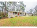 Home featuring a well-maintained lawn and brick facade, complemented by black shutters and a striking red front door at 3527 Glenview Sw Cir, Atlanta, GA 30331