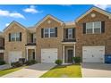 Charming brick townhome featuring a one-car garage, manicured lawn, and inviting front entrance at 815 Taurus Dr, Stockbridge, GA 30281