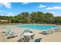 Resort-style pool surrounded by lounge chairs and lush greenery, perfect for relaxation and recreation at 815 Taurus Dr, Stockbridge, GA 30281
