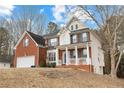 A charming two-story brick home with a two-car garage and a lovely front porch at 130 Brookridge Ct, Fayetteville, GA 30215