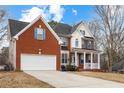 Side view of a two-story brick home with a two-car garage and front porch at 130 Brookridge Ct, Fayetteville, GA 30215
