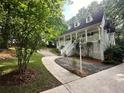 Charming two-story home featuring a welcoming front porch, a well-manicured lawn and a mature tree at 525 S Lost Lake Cv, Villa Rica, GA 30180