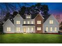 Exterior of a well-lit home at dusk with a manicured lawn at 1601 Shadow Ct, Dunwoody, GA 30338