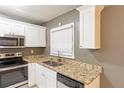 Well-lit kitchen with stainless steel appliances, granite countertops, and modern white cabinets at 285 Argus Nw Cir, Atlanta, GA 30331